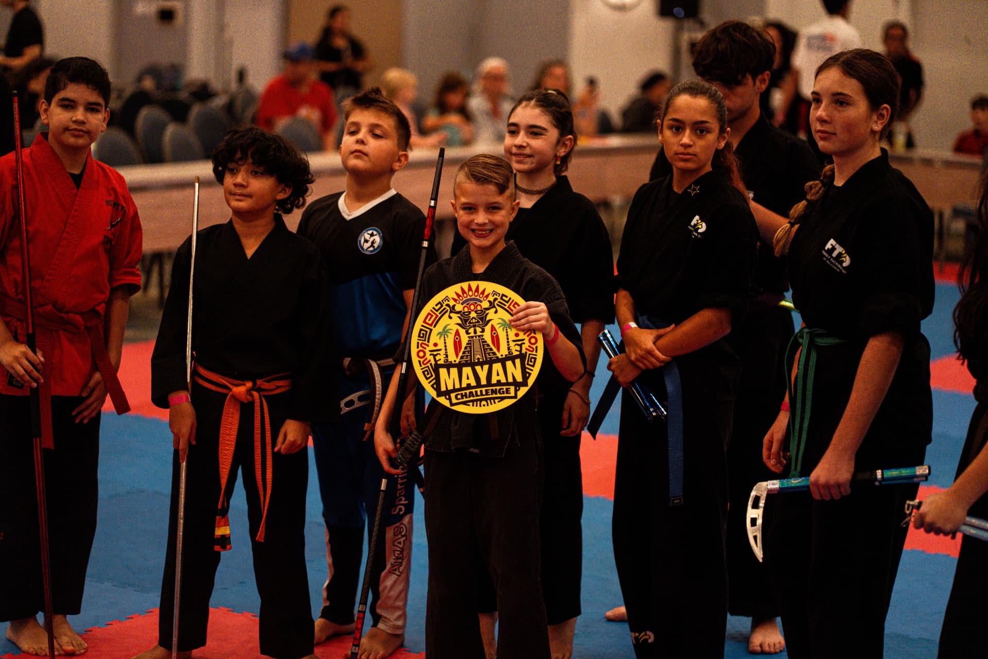 Athletes holding the Mayan Challenge award on the competition floor